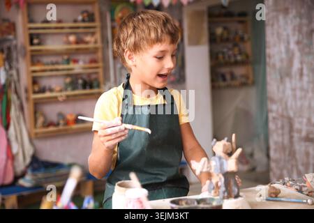 Kids molded from clay at pottery class. Stock Photo