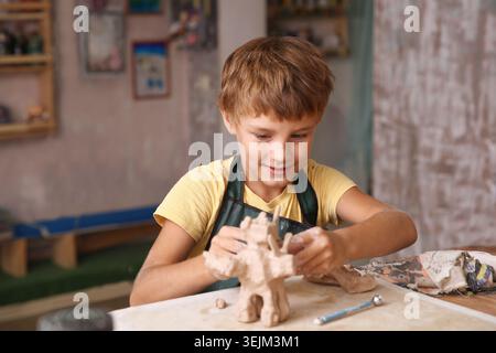Kids molded from clay at pottery class. Stock Photo