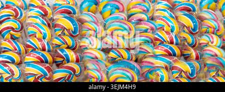 Color lollipops texture, spiral candy on stick, colorful striped lollypop, round fruit caramel, multicolored confectionery, circle lollipop closeup, s Stock Photo