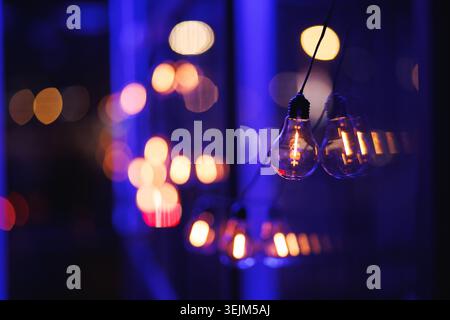 Vintage Edison Light Bulbs with Warm Bokeh on Blue Background Stock Photo