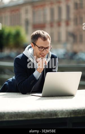 Freelance programmer or web designer read email on laptop computer walking city using 5g internet Stock Photo