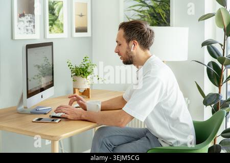Concentrated freelancer businessman type email on computer working from home on quarantine remotely Stock Photo