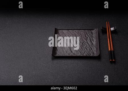 An empty ceramic square black plate with chopsticks for Asian food. An empty square plate Stock Photo