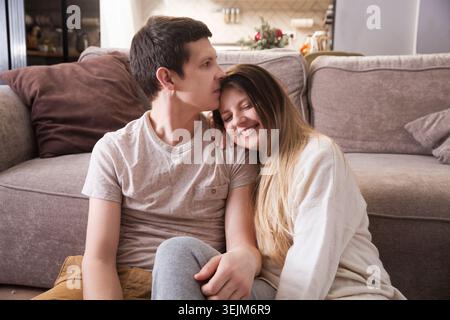 Family has fun spending time together at home. a loving couple sitting on the floor hugging and having fun together at home Stock Photo