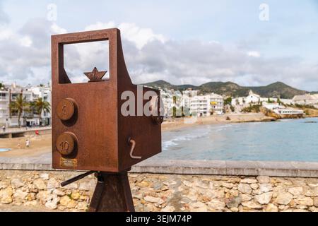 Sitges, Spain, 10 May 2026: Monument to Sitges Film Festival camera sculpture overlooking beach and seaside town in Spain Stock Photo