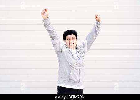 Sport and fitness. Senior sport. Active seniors. Senior woman stretching her legs outdoors on the sports ground Stock Photo
