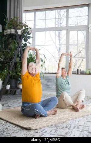 Elderly couple healthy lifestyle.  Senior couple doing exercises at home in the morning. Stock Photo