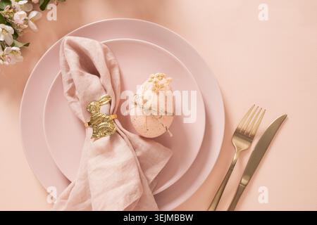 Easter egg decoration with golden bunny napkin ring on table setting Stock Photo