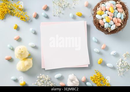Easter blank for greetings with yellow chicks, chocolate eggs, flowers. Stock Photo