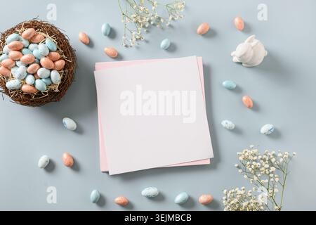 Easter blank for greetings with chocolate sweets as eggs, nest, and bunny. Stock Photo