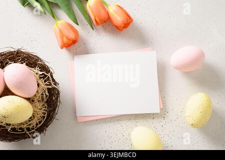 Easter greeting card with colorful eggs, decorative nest on white background. Stock Photo
