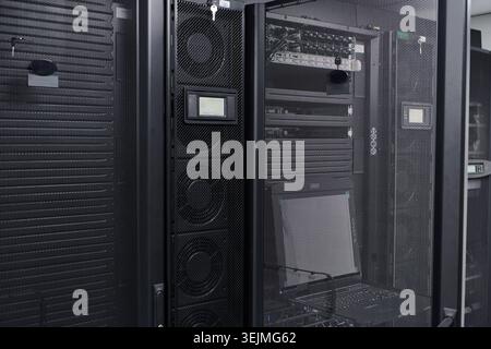Rows of modern server racks and network equipment housed in a secure data center environment, showcasing IT infrastructure, storage hardware, cooling Stock Photo