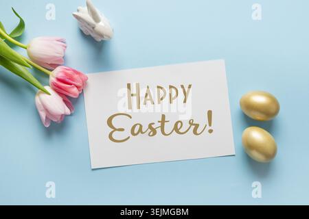 Easter greeting card with pink tulips, bunny, golden eggs on blue. Stock Photo