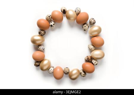 Easter wreath of golden, quail, chicken eggs isolated on white. Stock Photo