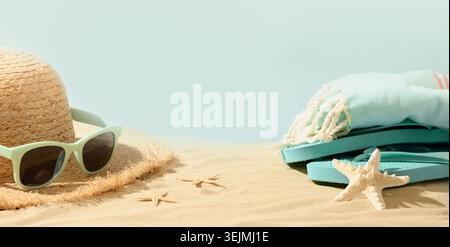 Beach straw sun hat, seashells and eyeglasses on sand. Summer holiday vacation. Stock Photo