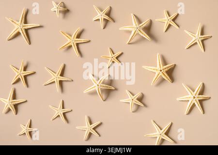 Starfishes on beige background as sand. Summer beach vacation. Stock Photo