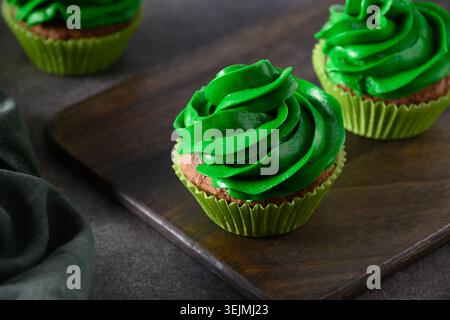Chocolate cupcakes with green whipped cream Stock Photo