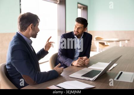 Two male executives discussing project in corporate office Stock Photo