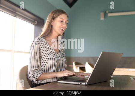 Female office employee feale typing on laptop in office Stock Photo