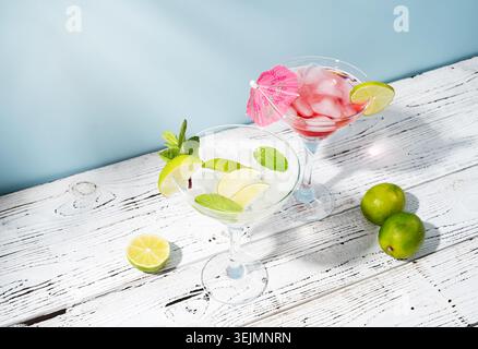 Fresh summer cocktails with strawberry, lime and ice cubes on blue background with copy space Stock Photo