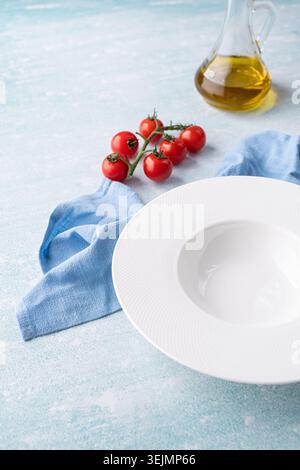 Empty plate for serving pasta or soup, on blue background with blue dining cloth Stock Photo