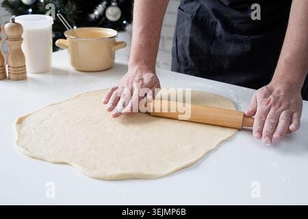 Male chef working with dough, cooking cinnamon rolls Stock Photo