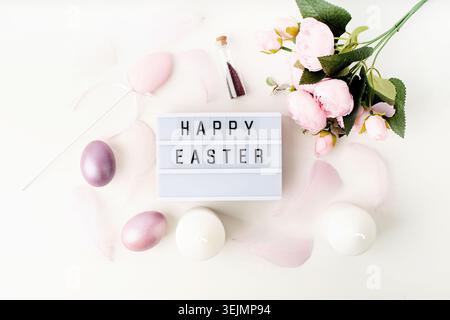 Top view Happy Easter light box decorated with pastel colored eggs and feathers Stock Photo