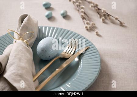 Easter table setting with blue egg and gold cutlery Stock Photo