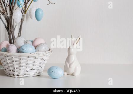 Easter tree with pastel eggs in vase and white bunny figurine vertical Stock Photo