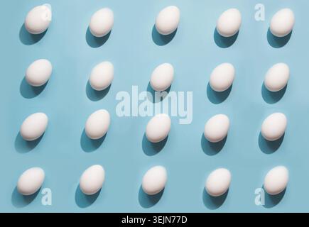 Organic white eggs on blue. Abstract pattern. Eggs in isometric. Stock Photo