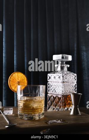 Cold whiskey served in rocks on dark blue curtain trendy background. Vertical format. Close up. Stock Photo