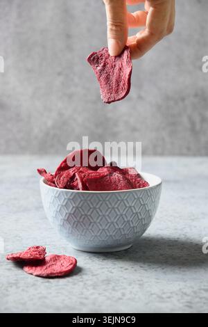 Vegetable vegan beetroot vegan chips in hand. Stock Photo
