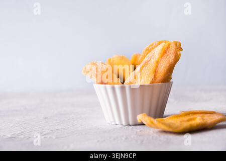 Dried mango chips on white. Close up. Stock Photo