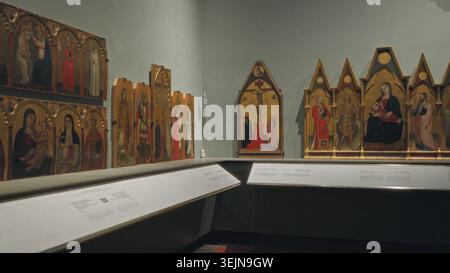 Museum gallery interior showing medieval painted altarpanels and wall labels in soft shallow focus, museum; background backplate copyspace calm. Stock Photo