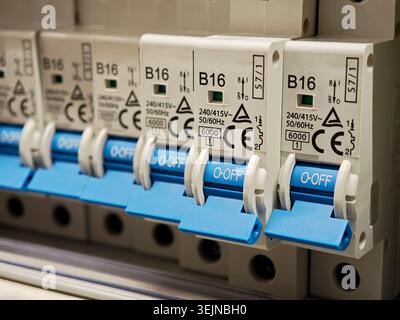 Close-up row of blue B16 miniature circuit breakers in an electrical distribution panel, off position switches for home wiring protection, safety equi Stock Photo