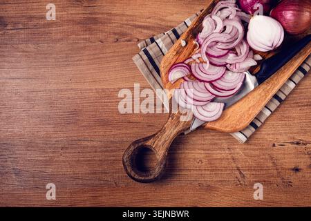 Sliced red onion, on a chopping board, with a knife,Spanish onion, raw onion, close-up, top view, Stock Photo