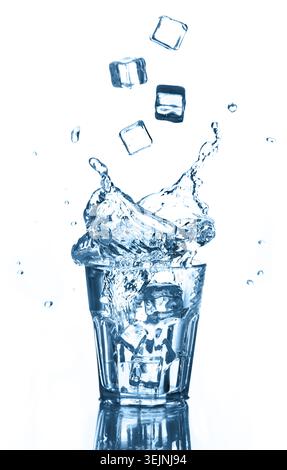 Splash of clean water with flying ice cubes in glass on white. Isolated. Healthy lifestyle. Stock Photo