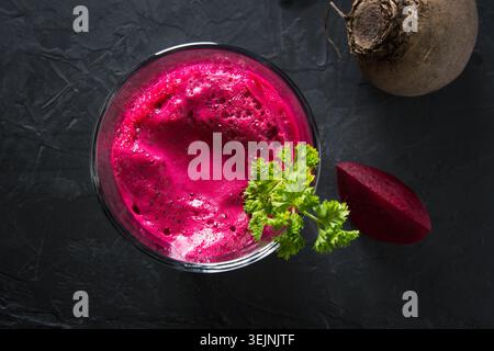 Glass of fresh beetroot juice garnish parsley on black. Stock Photo