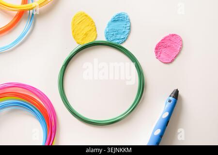Eggs of plastic for Easter. Rainbow plastic filaments with for 3D pen laying. Stock Photo