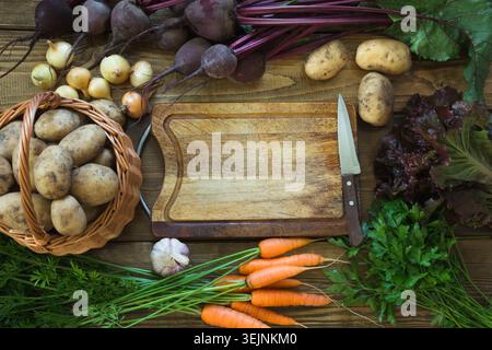 Fresh vegetables from carrot, beetroot, onion, potato on old wooden board. Top view. Copy space on cutting board. Stock Photo