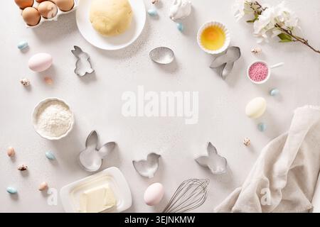 Preparation and cook Easter cookies, cookie cutters, raw dough on baking white background. Top view. Flat lay style. Stock Photo
