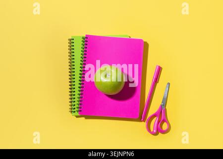 Bright school supplies, notebooks on yellow background. Top view. Copy space. Stock Photo