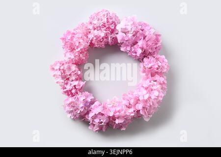 Pink hydrangea flowers as wreath on grey. Stock Photo