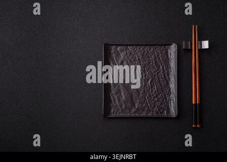 An empty ceramic square black plate with chopsticks for Asian food. An empty square plate Stock Photo