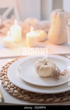 Thanksgiving day table setting with fall decorations of flowers and pumpkin. Stock Photo