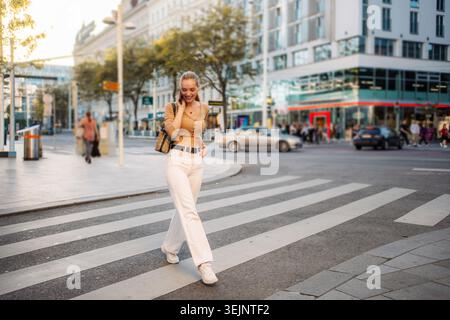 Young woman walking and talking on phone in Vienna Stock Photo