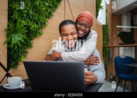Happy couple embracing, doing online shopping using laptop Stock Photo