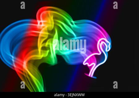 Neon blue flamingo LED lamp in motion as blurred abstract background on black. Stock Photo