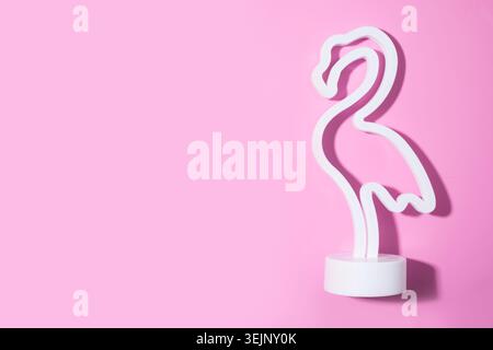 Neon pink flamingo LED lamp isolated on pink. Stock Photo