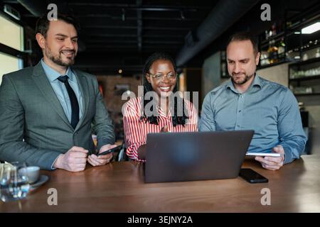 Diverse business team collaborating during meeting in cafe Stock Photo